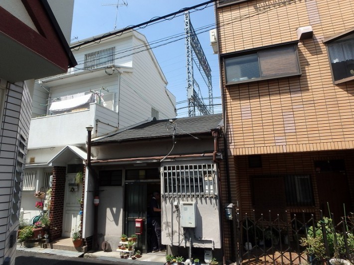 3F建てに挟まれた平屋
