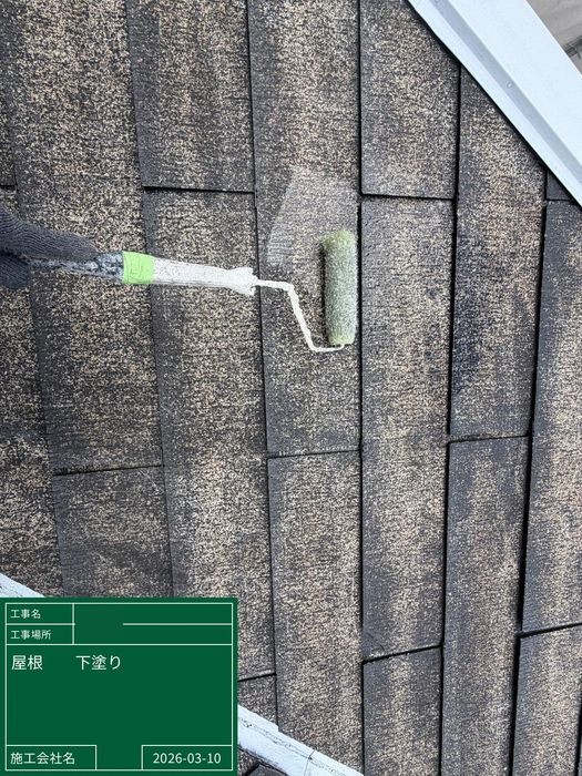 八尾市曙川東のT様邸 スレート屋根の下塗り施工中 職人がローラーで塗料を塗布している様子